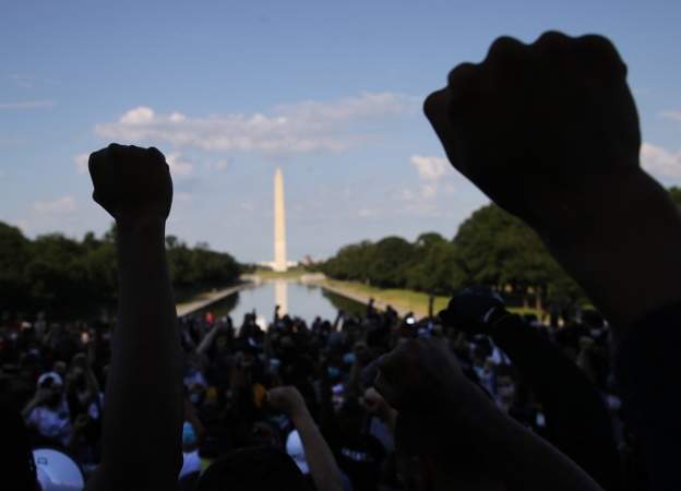 A-man-shouts-from-a-bullhorn-as-curfew-begins-to-take-effect-1